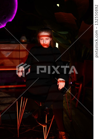 man gestures mysteriously, cinematic portrait of man in black coat gesturing mysteriously with neon 132550892