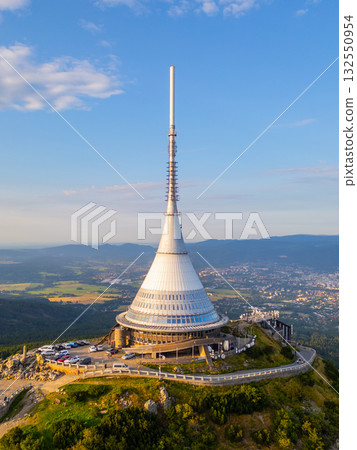 Jested Mountain Hotel stands majestically against the backdrop of a colorful sunset, showcasing its sleek, modern design. The surrounding landscape of Liberec offers stunning panoramic views. 132550954