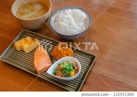 日式套餐早餐,包括烤鮭魚和玉子燒、燉南瓜和納豆。 日式套餐早餐,包括烤鮭魚和玉子燒、燉南瓜和納豆。 132551309