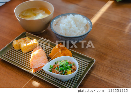 A Japanese set meal breakfast with grilled salmon and tamagoyaki, simmered pumpkin, and natto. A Japanese set meal breakfast with grilled salmon and tamagoyaki, simmered pumpkin, and natto. 132551315