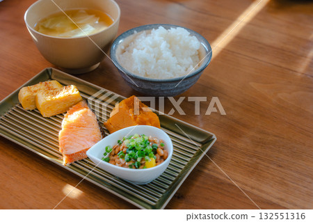 A Japanese set meal breakfast with grilled salmon and tamagoyaki, simmered pumpkin, and natto. 132551316