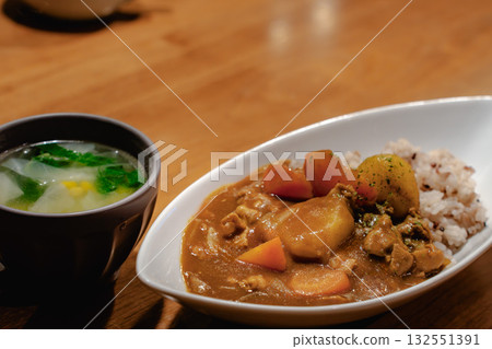 一頓家常晚餐,包括蔬菜咖哩飯和湯。 一頓家常晚餐,包括蔬菜咖哩飯和湯。 132551391