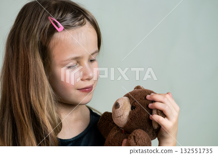 Pretty child girl playing with her teddy bear toy. 132551735