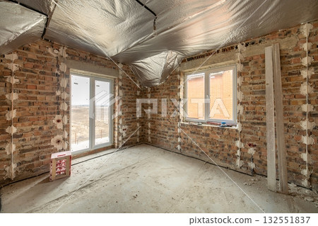 Interior of unfinished brick house with concrete floor and bare walls ready for plastering under construction. Real estate development Interior of unfinished brick house with concrete floor and bare walls ready for plastering under construction. Real estate development 132551837