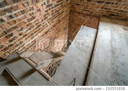 Interior of unfinished brick house with concrete floor and bare walls ready for plastering under construction. Real estate development 132551838