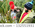 young couple man and woman have fun and fool around on the background of Christmas trees 132551931