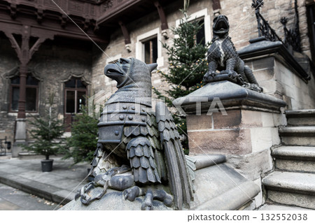 Stone griffin statues guard the courtyard of Wernigerode Castle with gothic strength and detail. Intricate carvings and medieval atmosphere reflect power, artistry, and mythic grandeur Stone griffin statues guard the courtyard of Wernigerode Castle with gothic strength and detail. Intricate carvings and medieval atmosphere reflect power, artistry, and mythic grandeur 132552038