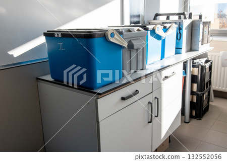 Blue plastic storage boxes on a laboratory counter.Automatic sampler equipment in laboratory setting. 132552056