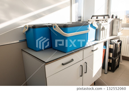 Blue plastic storage boxes on a laboratory counter.Automatic sampler equipment in laboratory setting. Blue plastic storage boxes on a laboratory counter.Automatic sampler equipment in laboratory setting. 132552060