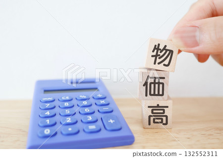 Wooden blocks and a blue calculator representing rising prices. Copy space available. Wooden blocks and a blue calculator representing rising prices. Copy space available. 132552311