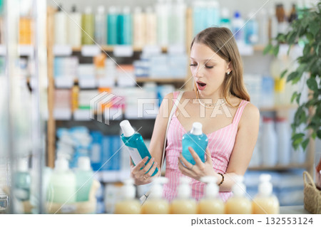 Blonde woman holding mouthwashes in her hands Blonde woman holding mouthwashes in her hands 132553124
