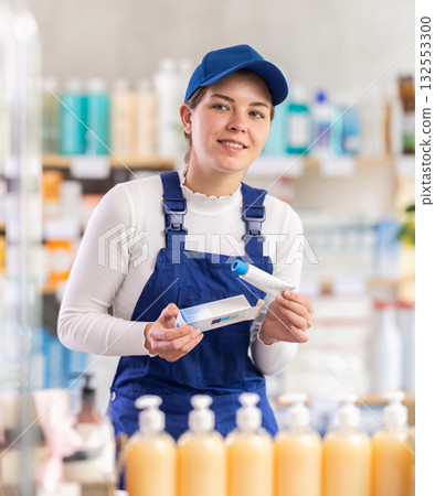 Young woman worker chooses ointment at pharmacy Young woman worker chooses ointment at pharmacy 132553300