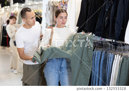 Couple man and woman choosing jeans Couple man and woman choosing jeans 132553328