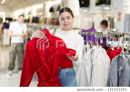 Young woman choosing coat in store 132553341