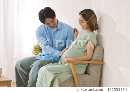 一對年輕夫婦在沙發上休息,孕婦 一對年輕夫婦在沙發上休息,孕婦 132553354