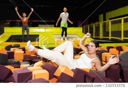 Joyful girl jumping into foam pit at indoor trampoline arena Joyful girl jumping into foam pit at indoor trampoline arena 132553378