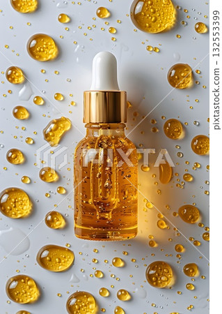 Golden serum in a glass dropper bottle with bubbles, water drops and bright reflections. Minimal luxury beauty concept Golden serum in a glass dropper bottle with bubbles, water drops and bright reflections. Minimal luxury beauty concept 132553399