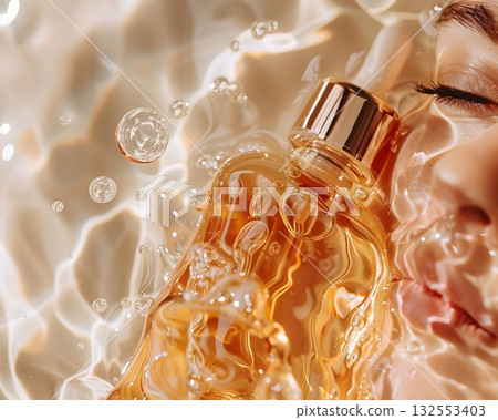 Golden serum in a glass dropper bottle with bubbles, water drops and bright reflections. Minimal luxury beauty concept Golden serum in a glass dropper bottle with bubbles, water drops and bright reflections. Minimal luxury beauty concept 132553403