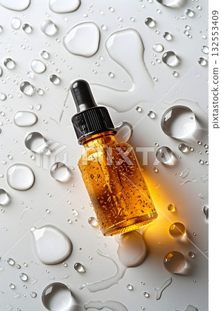 Golden serum in a glass dropper bottle with bubbles, water drops and bright reflections. Minimal luxury beauty concept 132553409