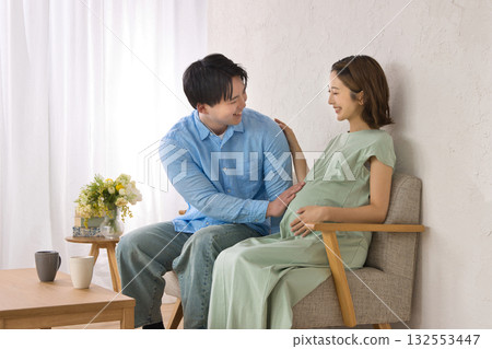 一對年輕夫婦在沙發上休息,孕婦 一對年輕夫婦在沙發上休息,孕婦 132553447