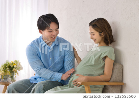 A young couple relaxing on the sofa, pregnant woman A young couple relaxing on the sofa, pregnant woman 132553500