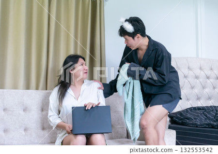 Two Thai LGBTQ friends sharing a morning moment one gently encouraging the other to take a shower showing care friendship and warmth in a real home scene 132553542