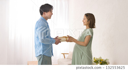Young partner giving a gift to a pregnant woman 132553625