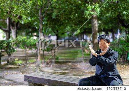 一位商人在夜間的公園展示「NG」。 132553740