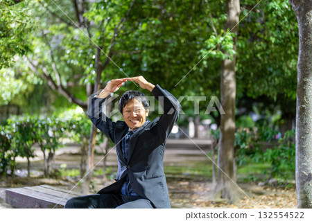 一名上班族在夜間的公園比出「OK」手勢 一名上班族在夜間的公園比出「OK」手勢 132554522