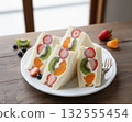 A white plate with colorful fruit sandwiches made with strawberries, kiwi, and mandarin oranges 132555454