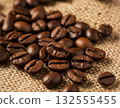 Close-up photo of the fragrant texture of roasted coffee beans spread on a burlap sack 132555455