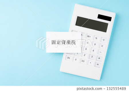 Property tax lettering and calculator on a light blue background 132555489