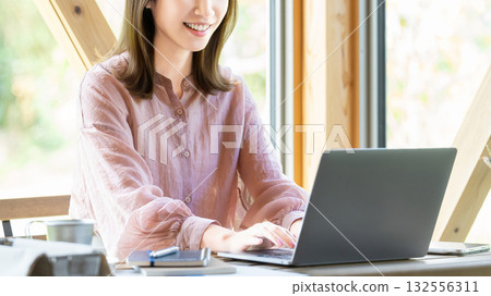 一位女士在咖啡館使用電腦。 132556311