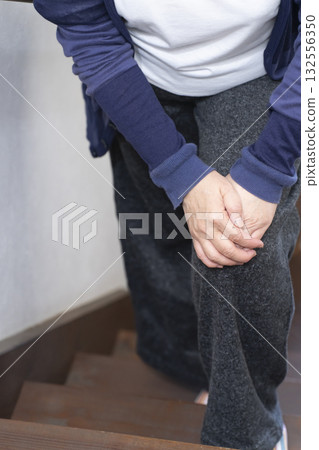 Senior woman with knee pain from going up and down stairs (no face) Senior woman with knee pain from going up and down stairs (no face) 132556350