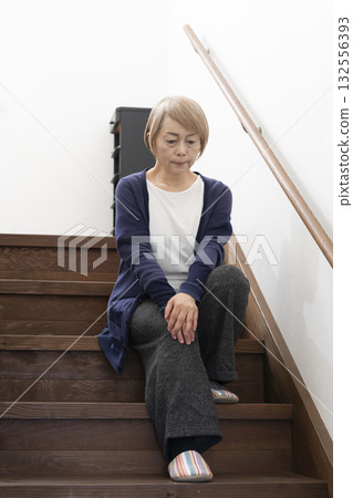 Senior woman with knee pain from going up and down stairs Senior woman with knee pain from going up and down stairs 132556393