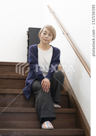 Senior woman with knee pain from going up and down stairs 132556395