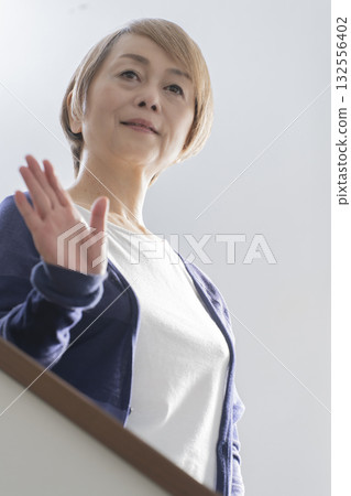Senior woman with knee pain from going up and down stairs 132556402