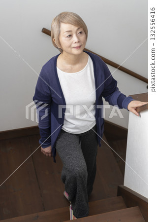 Senior woman with knee pain from going up and down stairs Senior woman with knee pain from going up and down stairs 132556416
