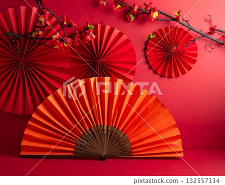 A traditional red Japanese folding fan opened with intricate paper patterns. 132557134