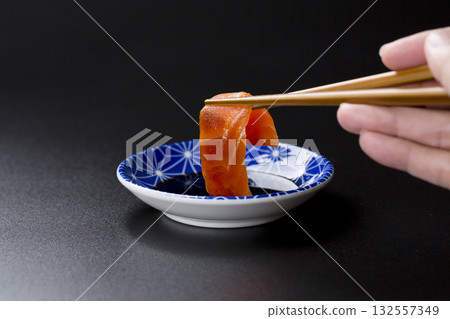 盛在盤子裡的鮭魚刺身,背景是黑色。 盛在盤子裡的鮭魚刺身,背景是黑色。 132557349