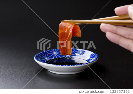 Salmon sashimi served on a plate against a black background Salmon sashimi served on a plate against a black background 132557351