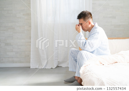 一名男子醒來時躺在床上，摀著眼睛 132557434