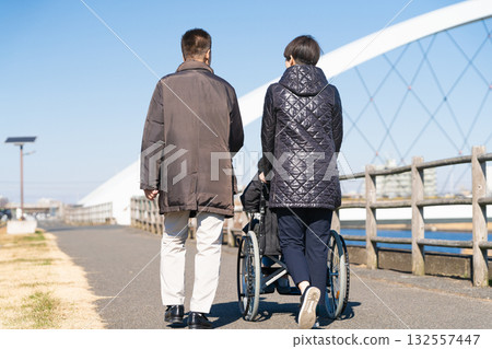 父母和孩子推著輪椅四處走動 父母和孩子推著輪椅四處走動 132557447