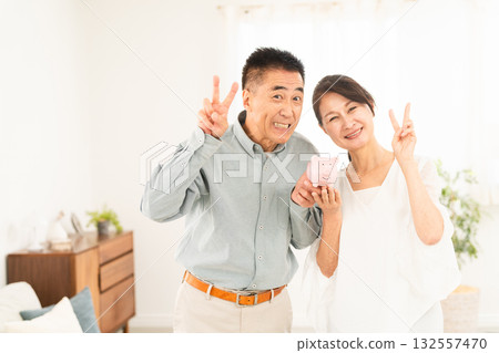 拿著存錢筒的成熟夫婦 拿著存錢筒的成熟夫婦 132557470