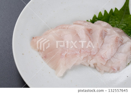 Sawara sashimi served on a plate against a black background Sawara sashimi served on a plate against a black background 132557645