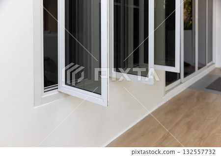 Three panel aluminium casement window stay on white wall. 132557732
