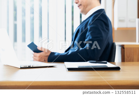 A businessman handling a smartphone hand A businessman handling a smartphone hand 132558511