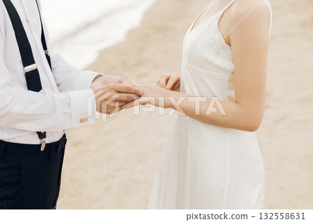 一個男人的手在女性上戴著一根手指 132558631