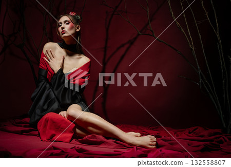 Woman poses gracefully in a traditional Japanese dress in studio setting with vivid backdrop Woman poses gracefully in a traditional Japanese dress in studio setting with vivid backdrop 132558807