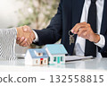 Real Estate Transaction. Agent handing over keys to new homeowner during contract signing. 132558815